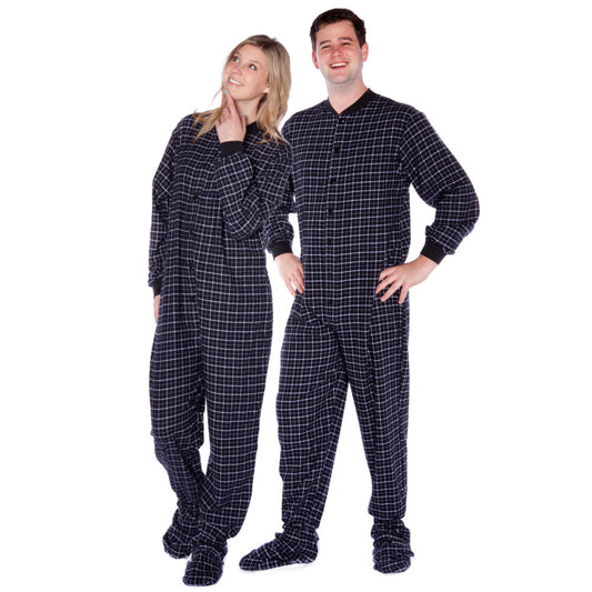A man and woman couple wearing Black & White Windowpane Plaid Adult Footed Onesie Pajamas from Big Feet Pajama Company