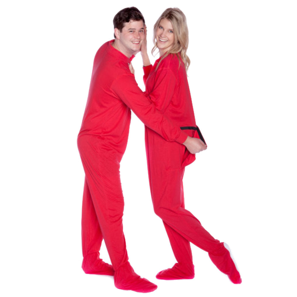A couple wearing Red Cotton Knit Adult Onesie Footed Pajamas, he is pulling on her onesie drop seat for fun, from Big Feet Pajama Company.