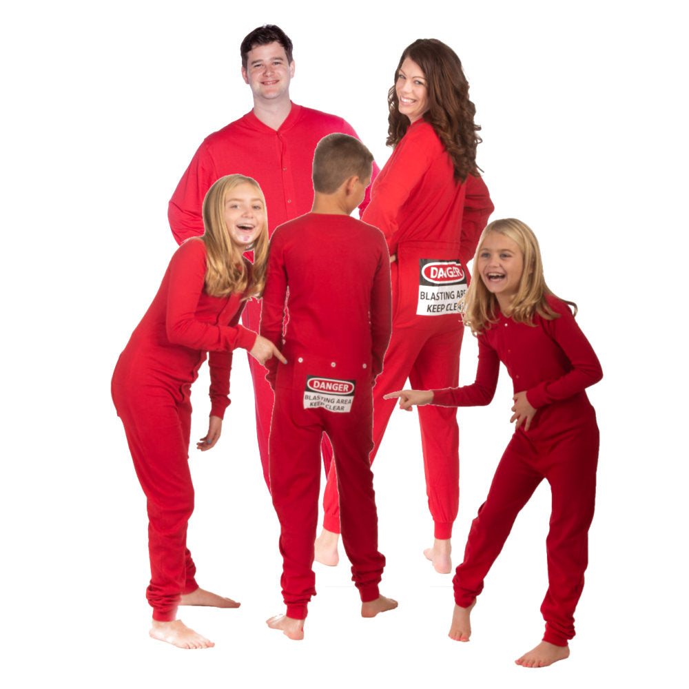 A family kids & parents wearing matching Red Cotton Knit Adult Footless Onesie Pajamas with the 2 young girls laughing pointing at brother's Funny Butt-Flap - says DANGER - BLASTING AREA - KEEP CLEAR, from Big Feet Pajama Company.