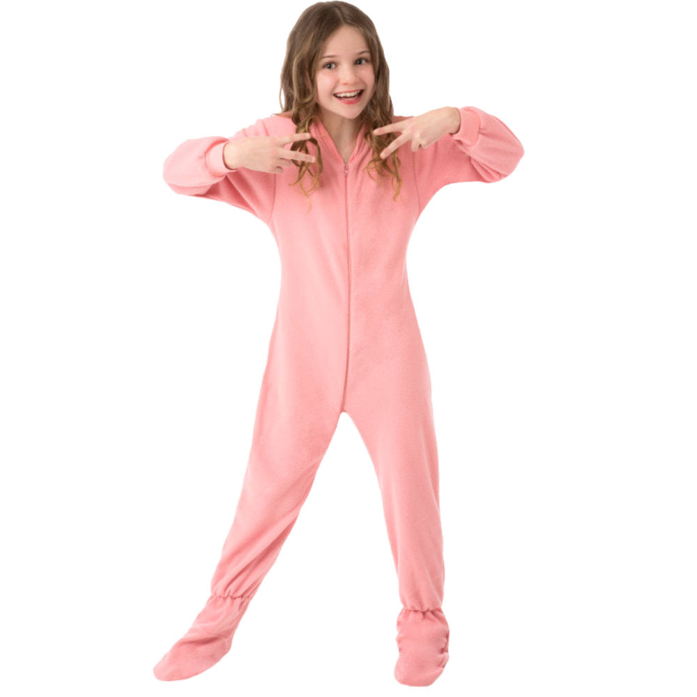 A young girl smiling showing off her Birthday Gift, new Pink Fleece Onesie Footie Pajamas for kids from Big Feet Pajama Company.