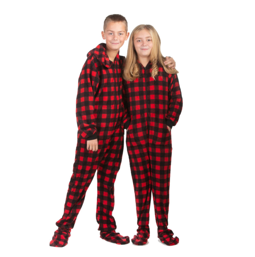 A boy and girl in their teens wearing matching red & black buffalo plaid fleece onesie footed pajamas from Big Feet Pajama Company.