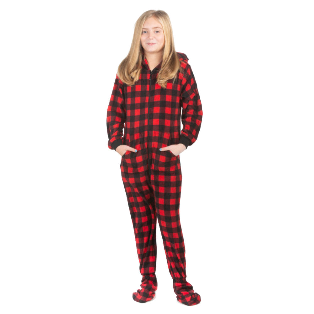 A young girl, wearing one-piece pjs from the Big Feet Pajama Company line of comfy, fleece footed onesies that make getting ready for bed and relaxing at home easy. This outfit is made of fleece, with the pattern being in Red and Black plaid. She is posing with her hands in her pockets.