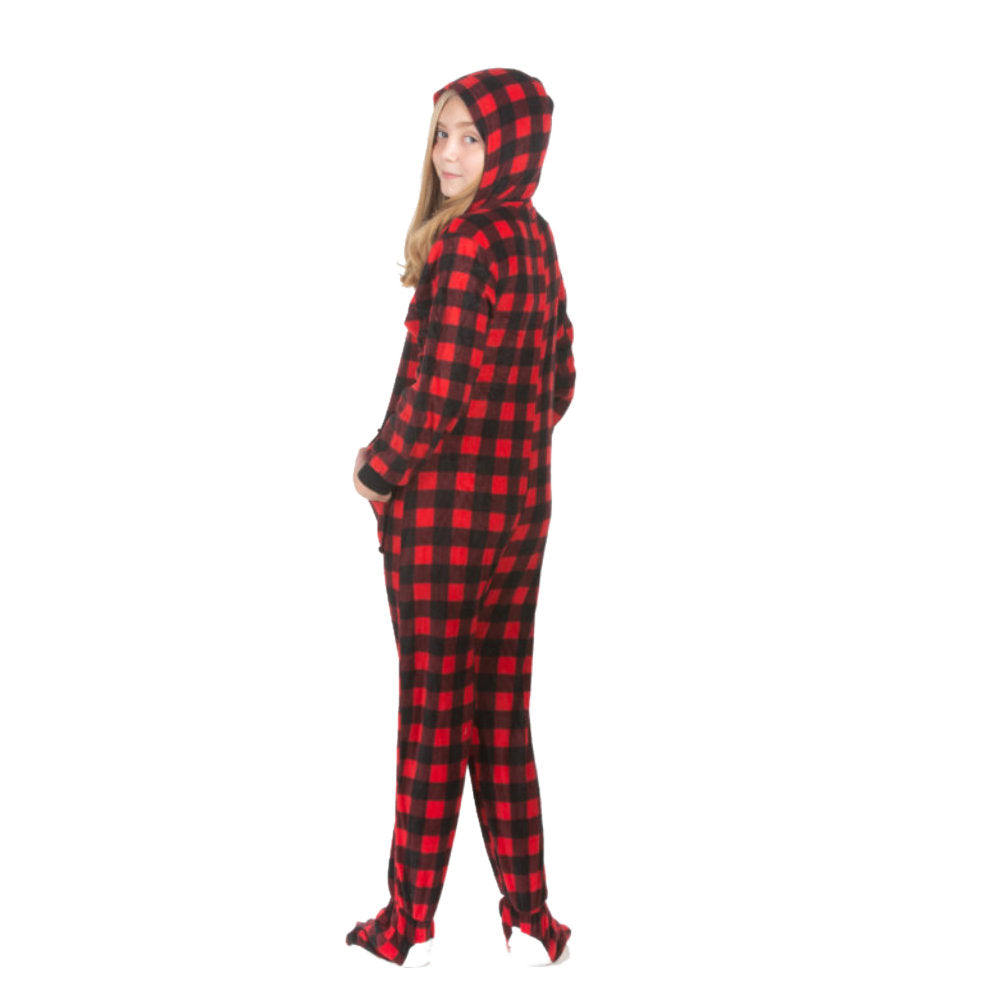 A young girl, wearing hoodie footie pjs from the Big Feet Pajama Company line of comfy fleece footed onesies that make getting ready for bed fun and easy. This outfit is made of red & black checkered buffalo plaid fleece, and she is posing with her hood on and hands in the kangaroo pockets.
