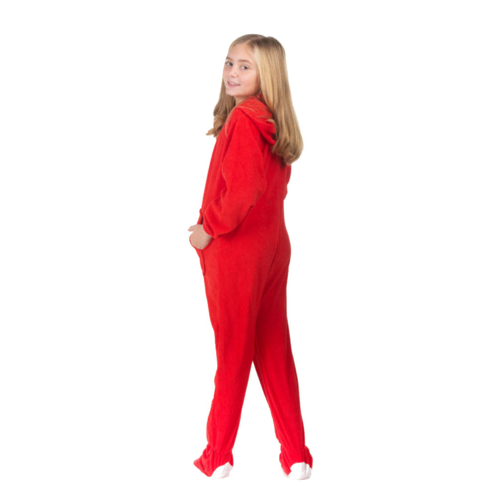 A girl posing for Christmas pictures wearing her red fleece hoodie-footed onesie pajamas from the Big Feet Pajama Company.