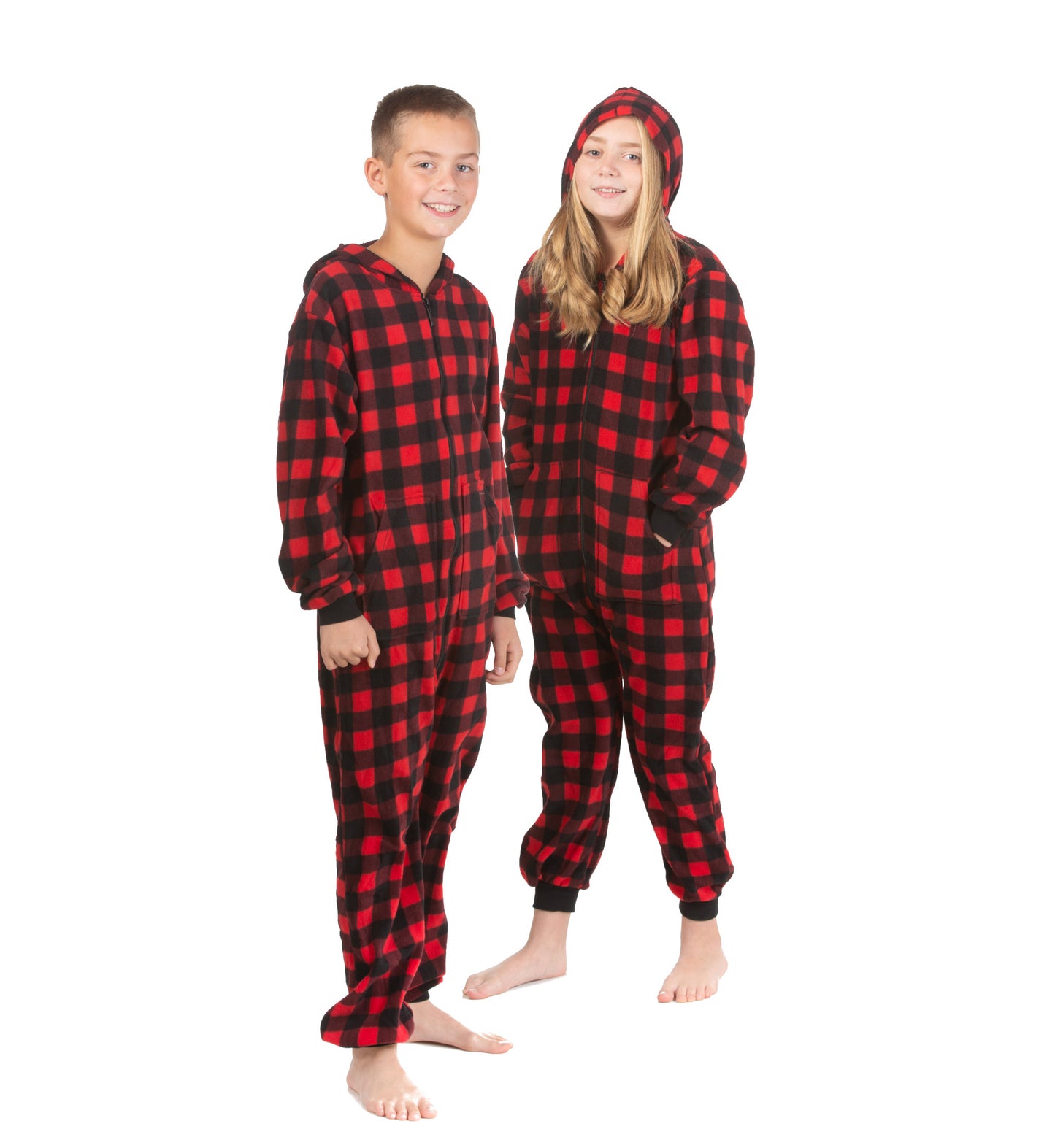 A boy and girl are wearing hoodie jumpsuit pjs from the Big Feet Pajama Company line of matching family onesies pajamas. This one-piece outfit is footless and made of Red and Black Buffalo plaid micro-polar fleece.