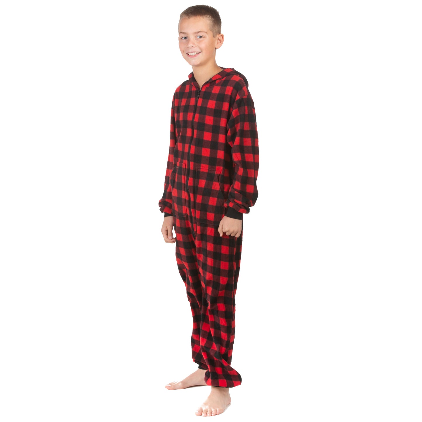 A boy is wearing one-piece jumpsuit-style pajamas from the Big Feet Pajama Company line of warm fleece footless onesies that make getting ready for bed and relaxing at home easy. This outfit is made of Red and Black Buffalo plaid polar fleece.