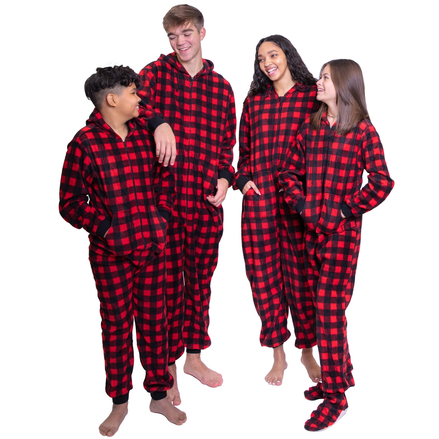 A blended family of four young adults is having fun during a Christmas photo session. They are wearing matching Buffalo Plaid Onesie Pajamas and Jumpsuits from Big Feet Pajama Company's fleece red and black buffalo plaid line of footed and non-footed hoodie onesies.