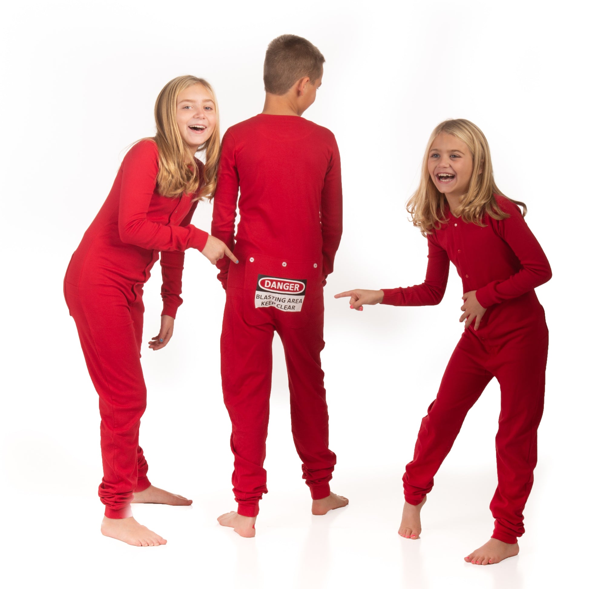 Three children laughing wearing red onesie pajamas with a 'Danger Blast Area' sign on a white background on the rear.